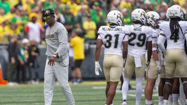 Colorado coach Deion Sanders leaves his team's huddle during timeout against Oregon.